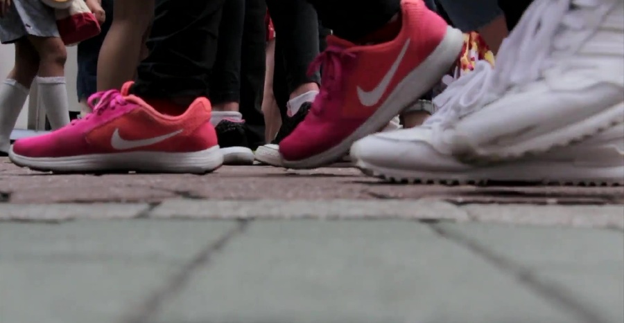 Image of several individuals' shoes and they walk up board walk